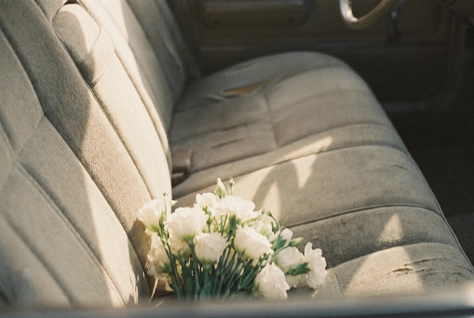 Un ramo de flores silvestres sobre el asiento de un coche viejo